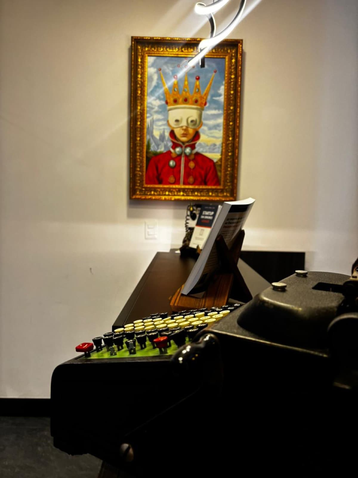 Retrato coronado junto a una máquina de escribir Remington