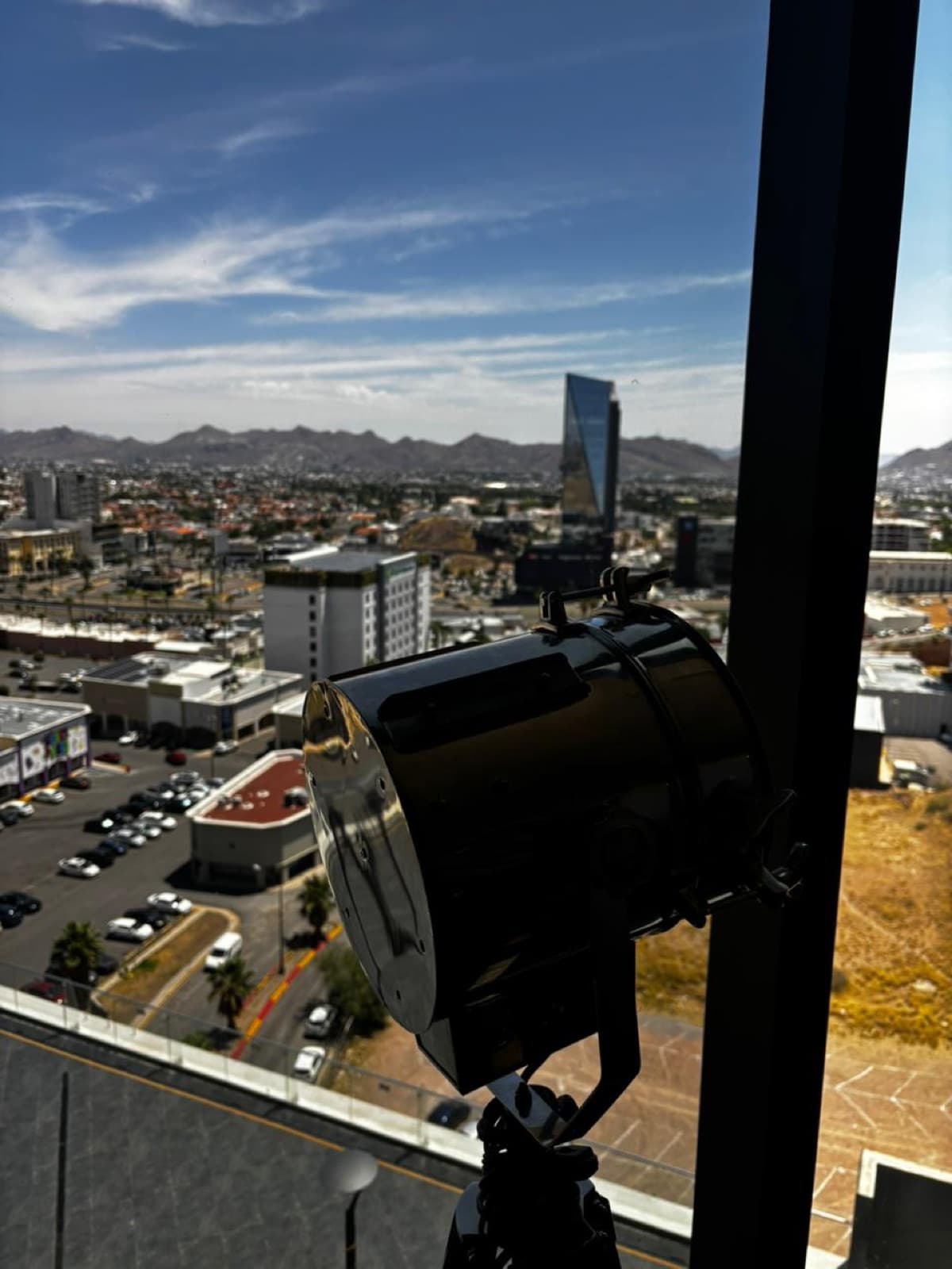 Reflector vintage apuntando a la ciudad desde el ventanal